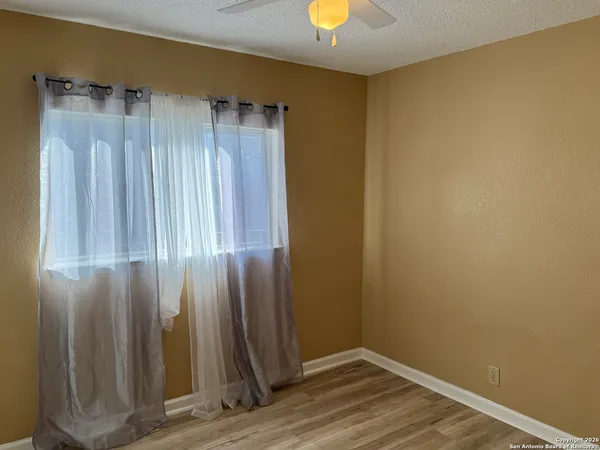 an empty room with wooden floor and a window