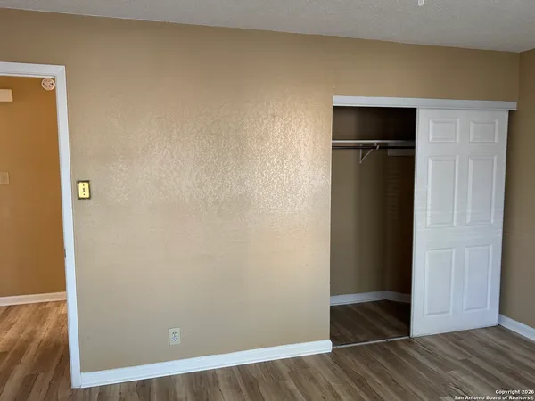 an empty room with wooden floor and closet
