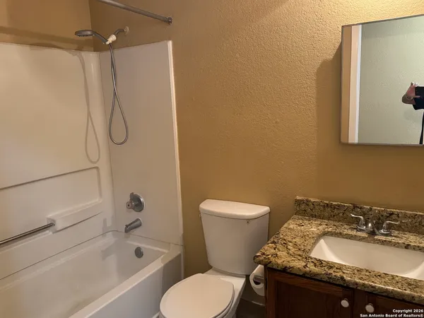 a bathroom with a granite countertop toilet sink and shower