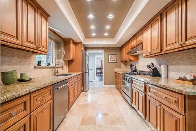 a large kitchen with stainless steel appliances granite countertop a sink and cabinets