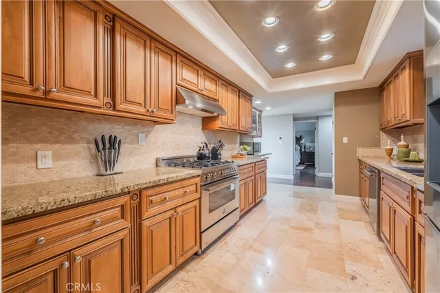 a large kitchen with granite countertop a sink stainless steel appliances and cabinets