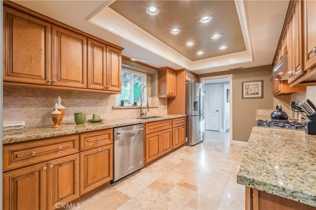 a large kitchen with granite countertop a sink and dishwasher a stove top oven with wooden floor