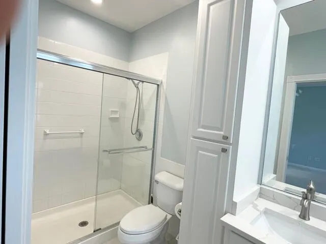 a bathroom with a shower a toilet and a sink