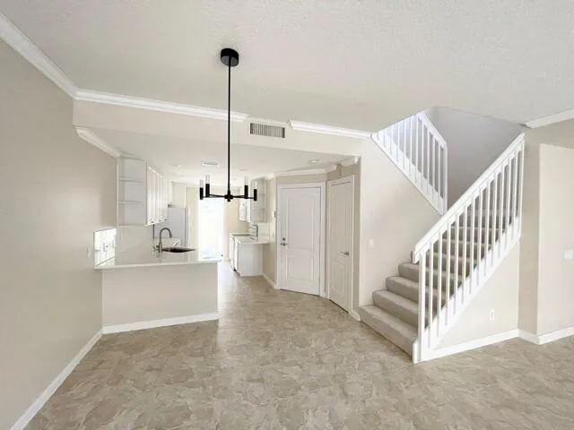 a view of a kitchen with a sink and white cabinets