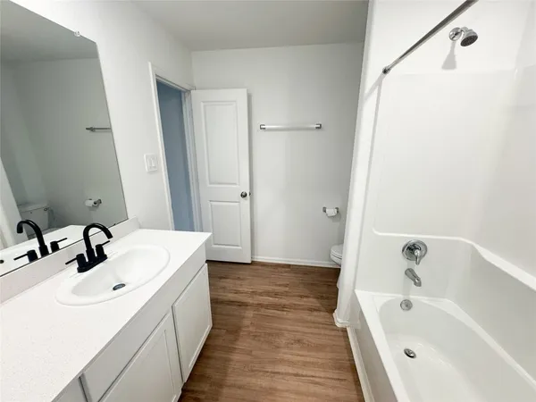 a bathroom with a tub sink and mirror