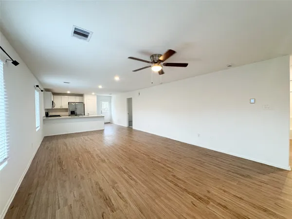 a view of empty room with wooden floor and window