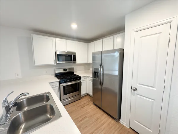 a kitchen with a refrigerator sink and microwave