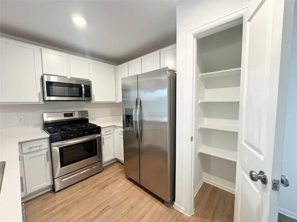 a kitchen with a refrigerator stove and microwave