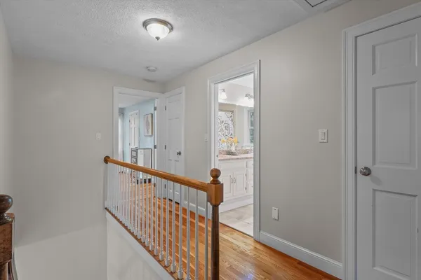 a view of a hallway with wooden floor and stairs