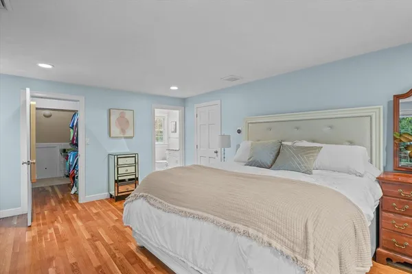 a spacious bedroom with a bed and a flat screen tv