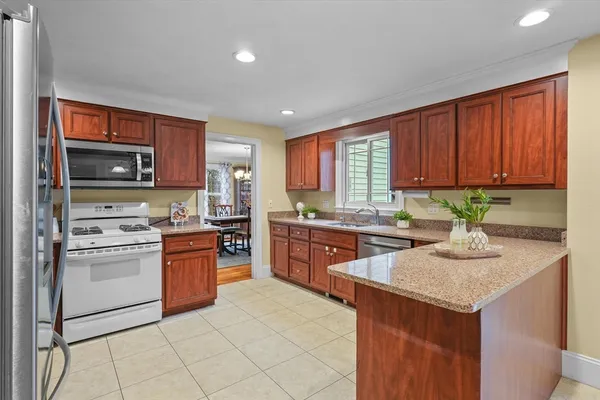 a kitchen with stainless steel appliances granite countertop wooden cabinets a stove top oven a sink and dishwasher