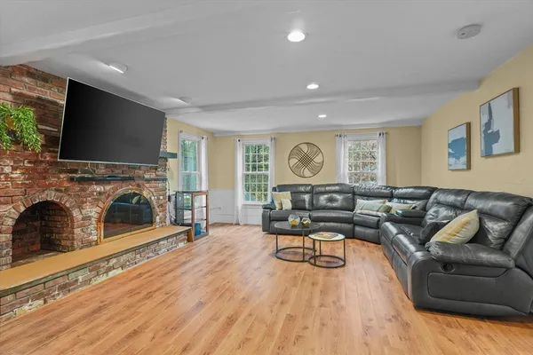 a living room with furniture a fireplace and a flat screen tv