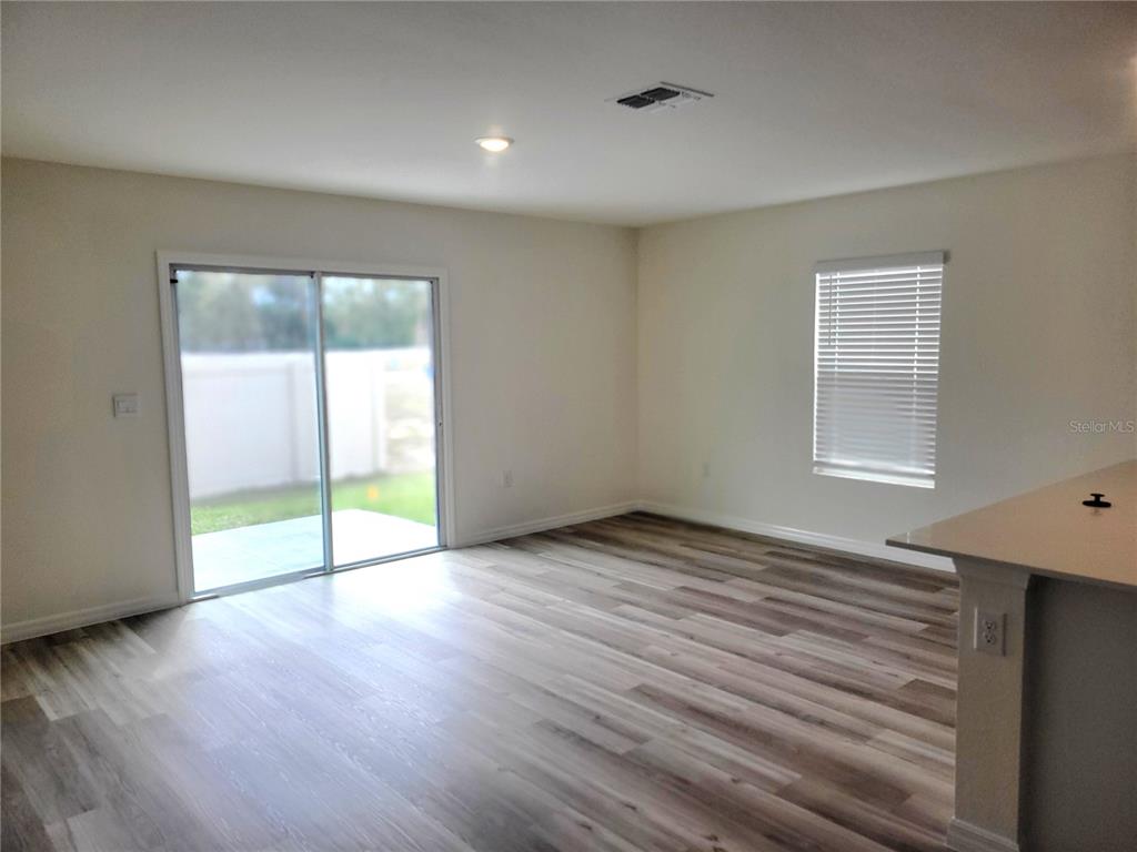 6534 Southwest 82nd Loop Ocala, FL 34476 - Photo 3 of 13 a view of an empty room with wooden floor and a window