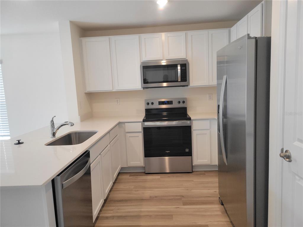 6534 Southwest 82nd Loop Ocala, FL 34476 - Photo 4 of 13 a kitchen with stainless steel appliances a refrigerator stove and sink
