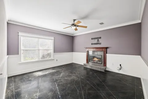 a view of an empty room with window and a kitchen