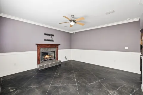 a view of an empty room with a fireplace and a fan