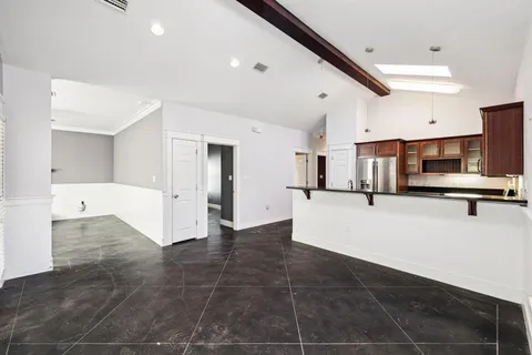a view of kitchen with stainless steel appliances a refrigerator and cabinets
