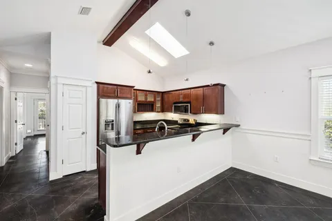 a kitchen with stainless steel appliances a stove a refrigerator and a window