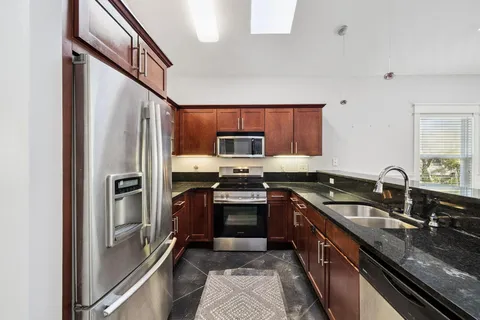 a kitchen with granite countertop stainless steel appliances and a sink