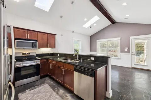 a kitchen with granite countertop a stove and a sink