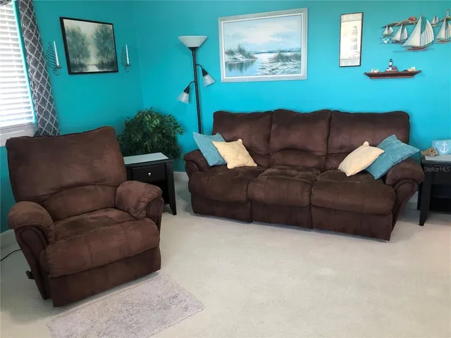 a living room with furniture a couch and a painting on the wall