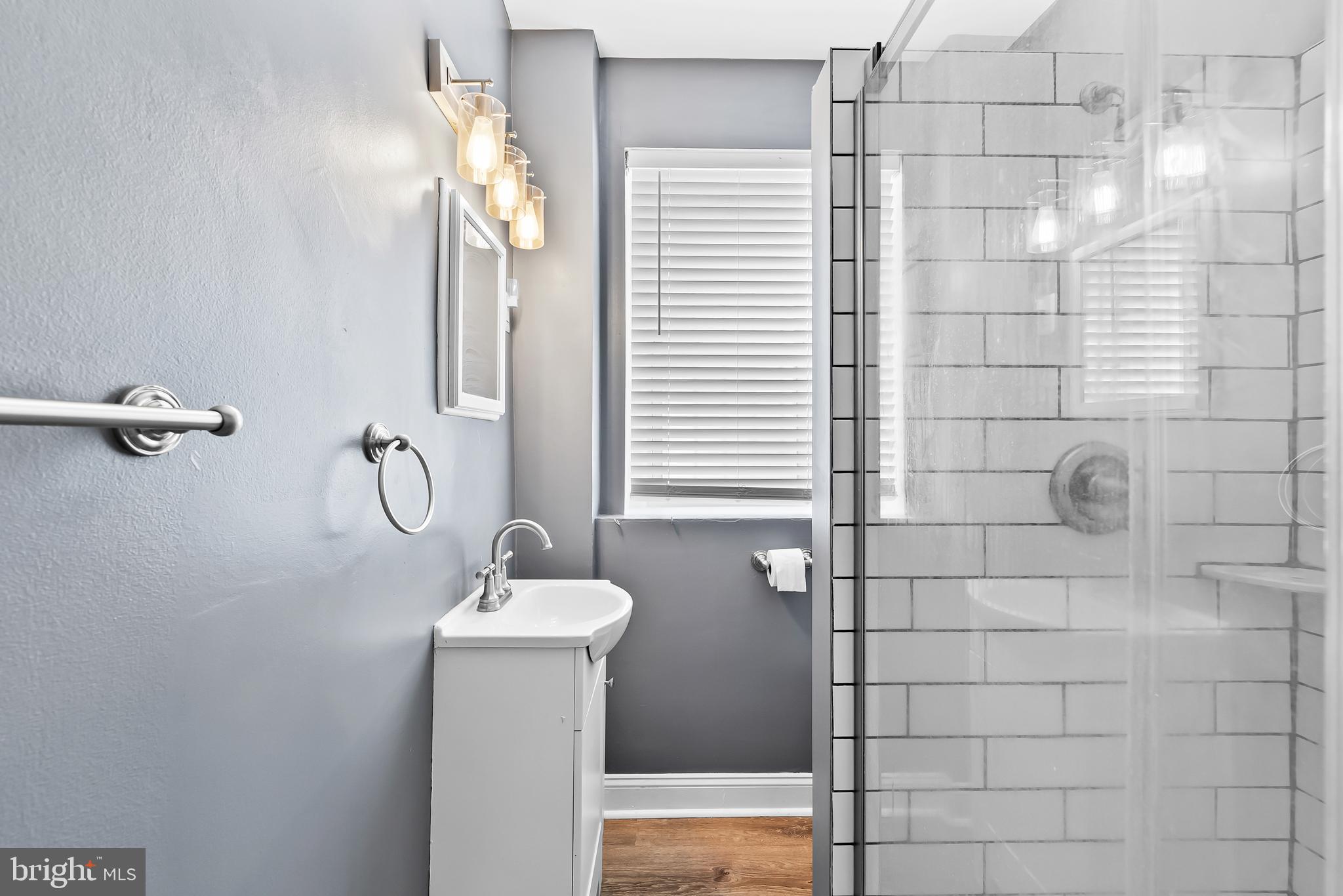 115 2nd Street Northeast, Unit 16 Washington, DC 20002 - Photo 15 of 21 a bathroom with a sink a mirror and shower
