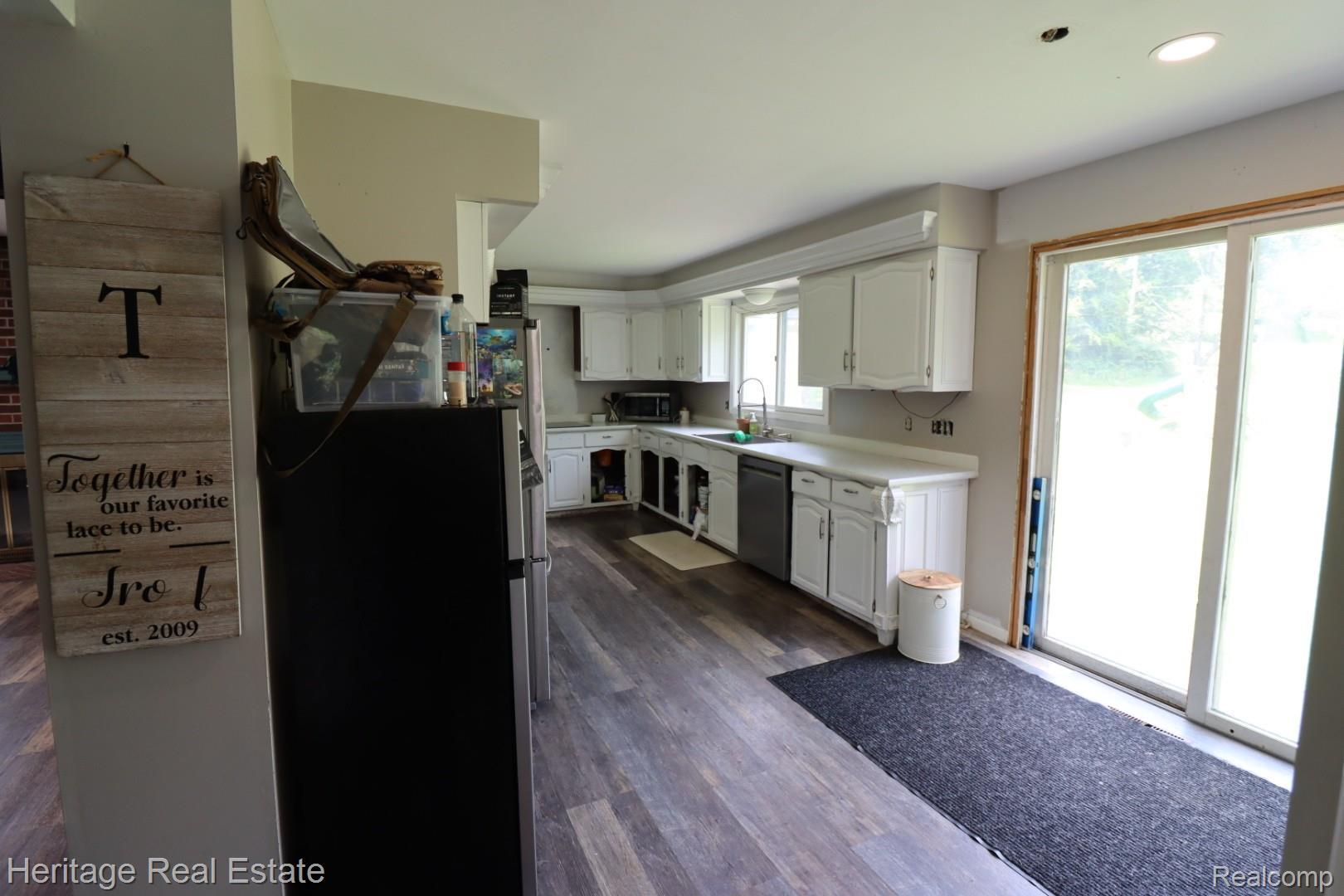 445 Mack Road Leonard, MI 48367 - Photo 13 of 41 Kitchen with white cabinetry, wood-finish flooring, and a sliding glass door