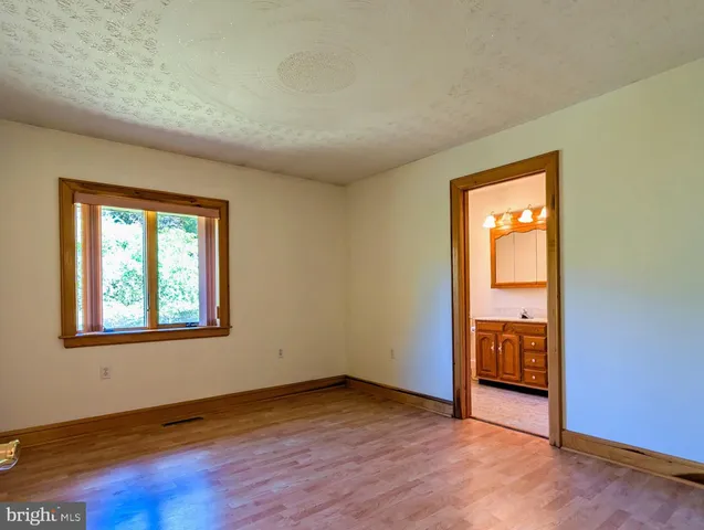 a view of a house with table and chairs under an umbrella