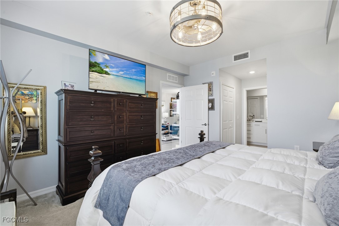 43993 Boardwalk Loop, Unit 1925 Punta Gorda, FL 33982 - Photo 15 of 35 a bedroom with a bed and a chandelier