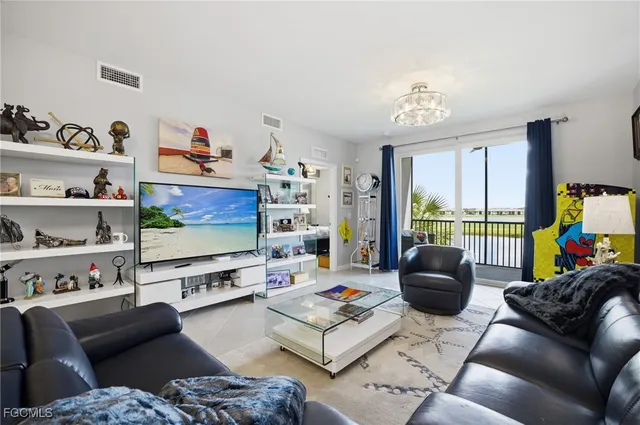 a living room with furniture a flat screen tv and a floor to ceiling window