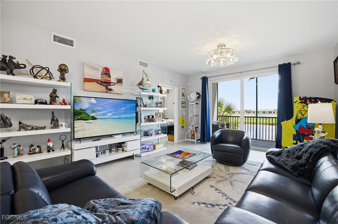 43993 Boardwalk Loop, Unit 1925 Punta Gorda, FL 33982 - Photo 4 of 35 a living room with furniture a flat screen tv and a floor to ceiling window