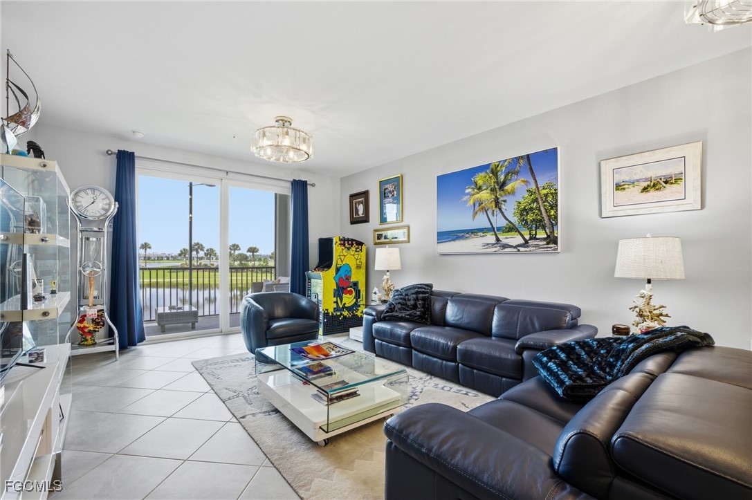 43993 Boardwalk Loop, Unit 1925 Punta Gorda, FL 33982 - Photo 8 of 35 a living room with furniture a flat screen tv and a floor to ceiling window
