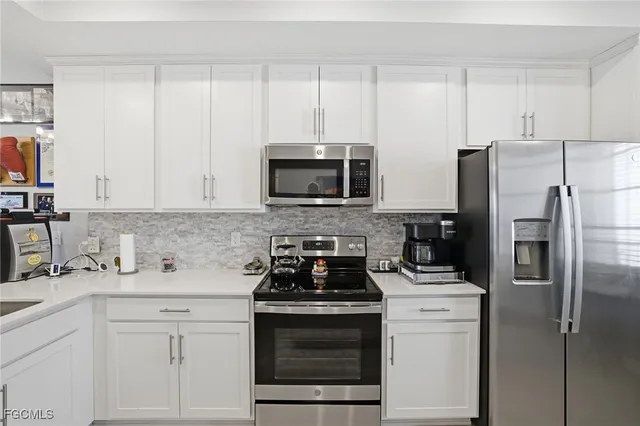 a kitchen with appliances a sink and cabinets