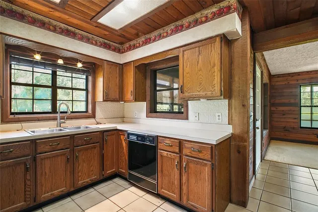 a view of an empty room with window and chandelier fan