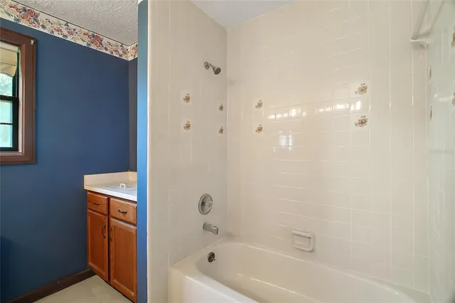 an empty room with a window and ceiling fan