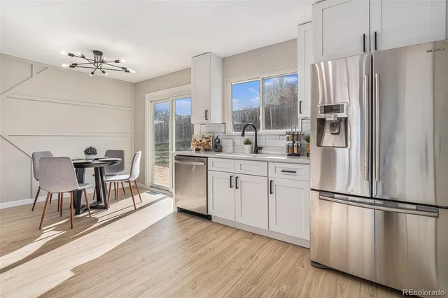 a kitchen with white cabinets and stainless steel appliances