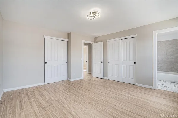 a view of empty room with wooden floor