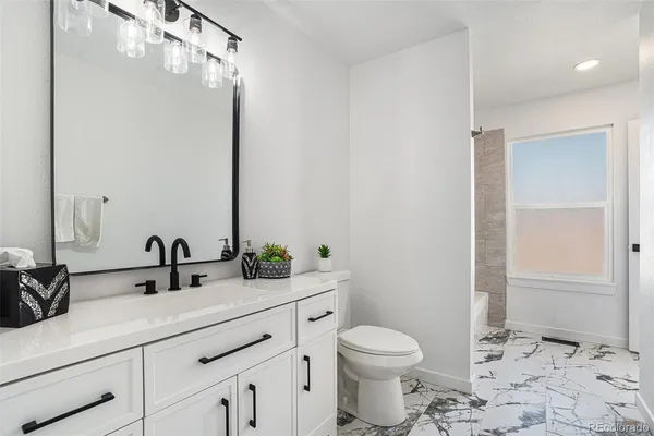 a bathroom with a double vanity sink toilet and shower