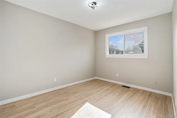 a view of empty room with wooden floor