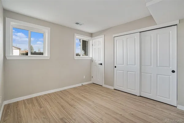 a view of an empty room with wooden floor
