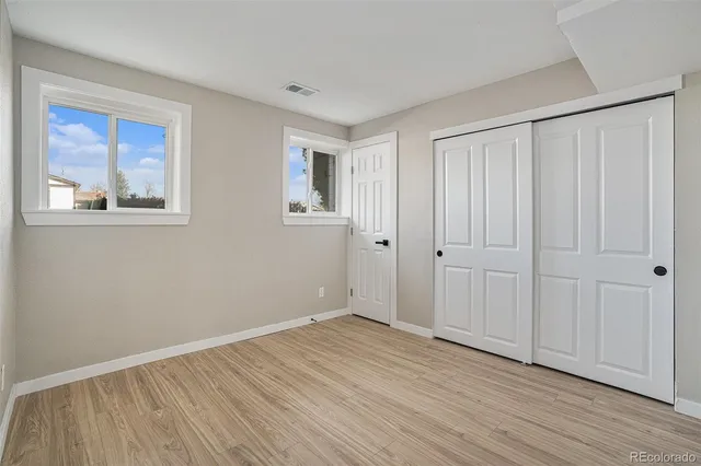 a view of an empty room with wooden floor