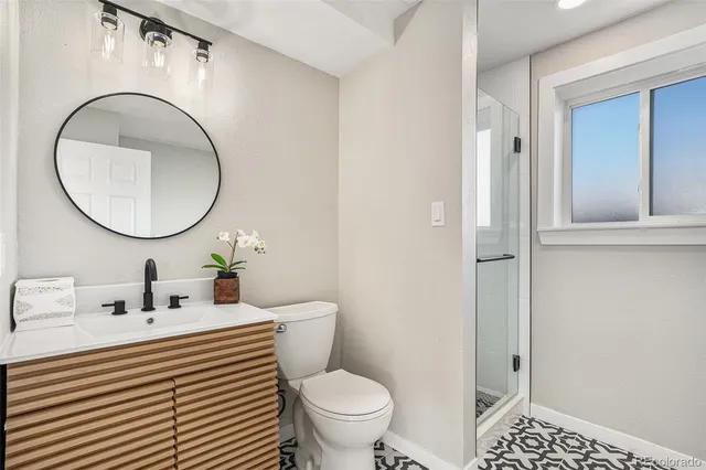a bathroom with a sink a toilet and a mirror