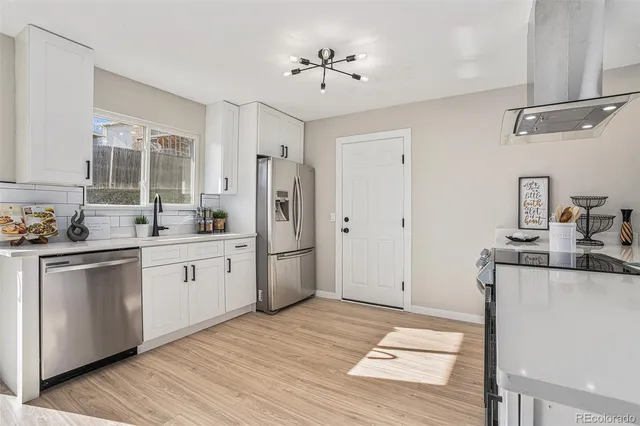 a kitchen with stainless steel appliances a stove refrigerator sink and cabinets