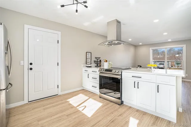 a kitchen with a stove cabinets and wooden floor