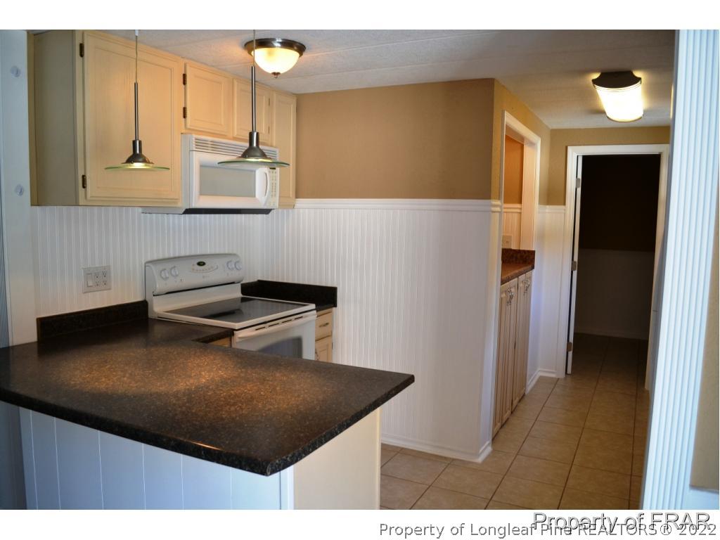 105 Beard Road Raeford, NC 28376 - Photo 4 of 29 a kitchen with stainless steel appliances granite countertop a sink a stove and a refrigerator