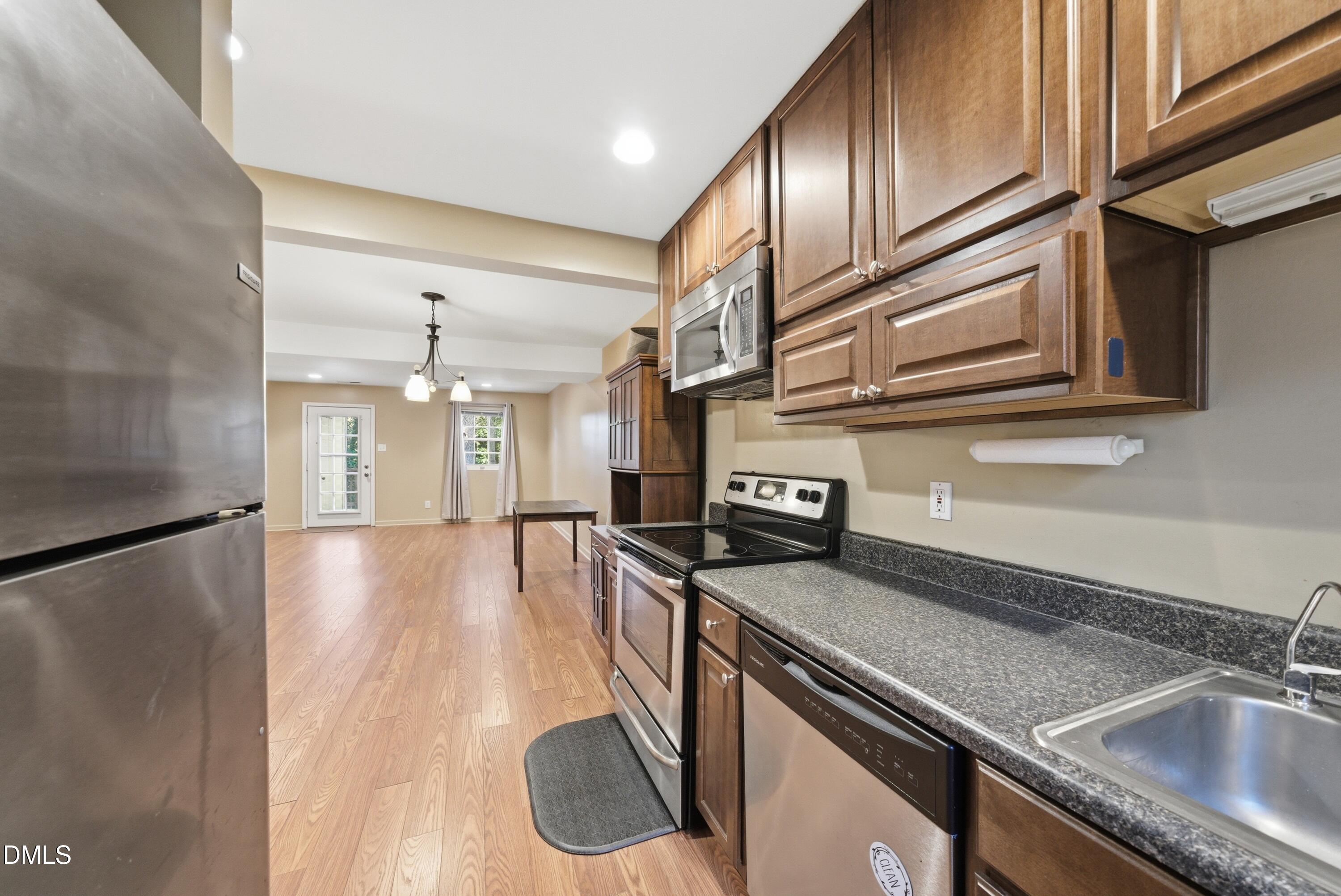 6355 New Market Way Raleigh, NC 27615 - Photo 13 of 30 a kitchen with stainless steel appliances granite countertop a sink a stove and a refrigerator