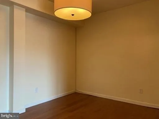 an empty room with a wooden floor and a window