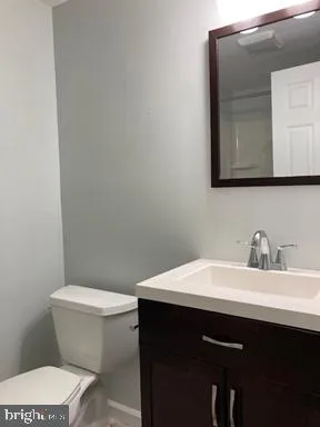 a bathroom with a sink a toilet and mirror