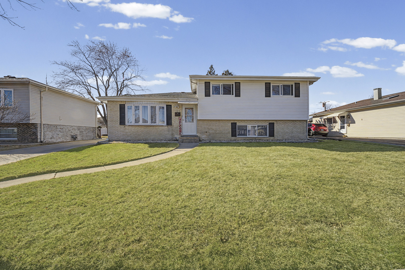 102 South Adeline Avenue Addison, IL 60101 - Photo 2 of 20 a view of a house with a big yard and large trees