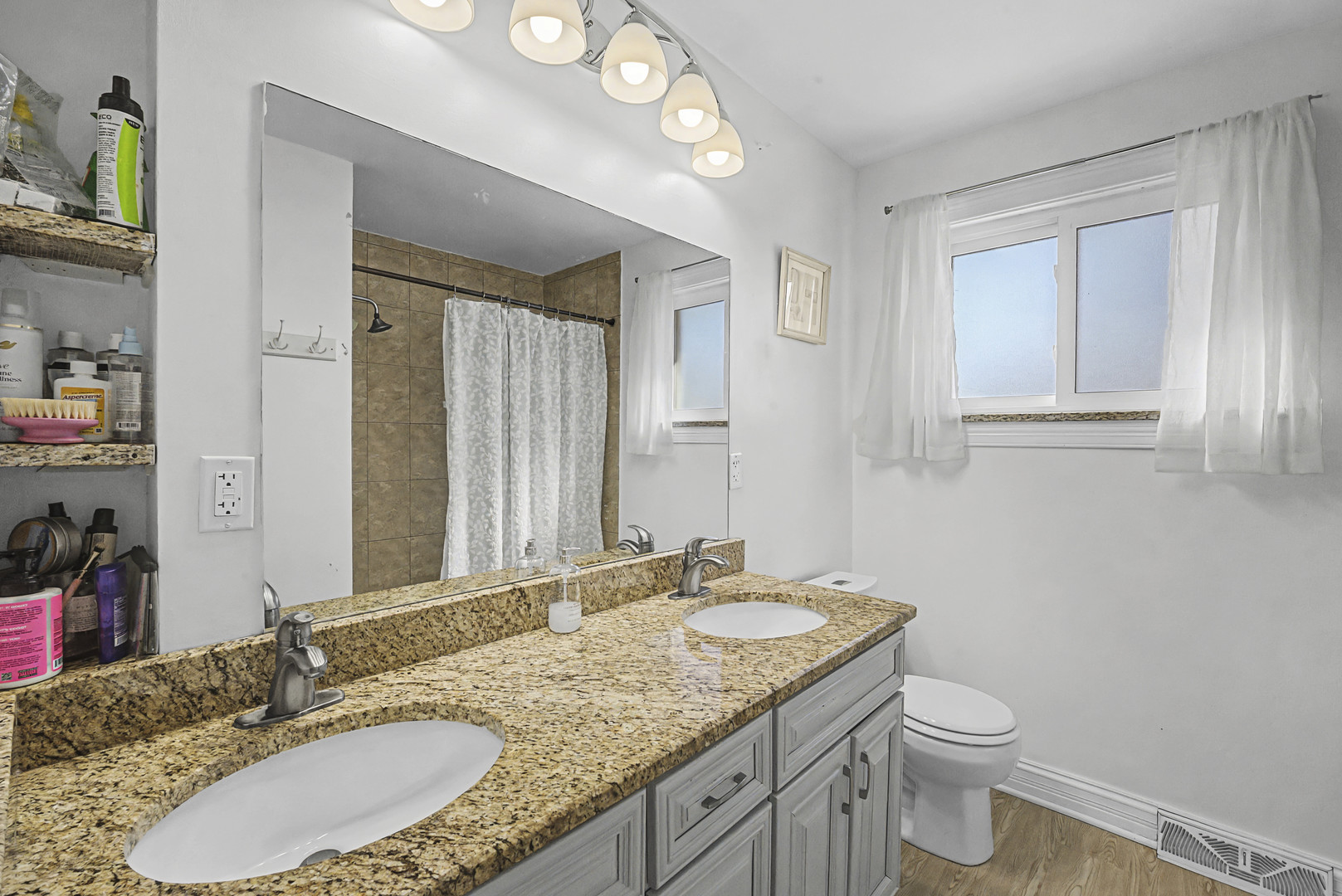 102 South Adeline Avenue Addison, IL 60101 - Photo 10 of 20 a bathroom with a granite countertop sink a toilet and a mirror
